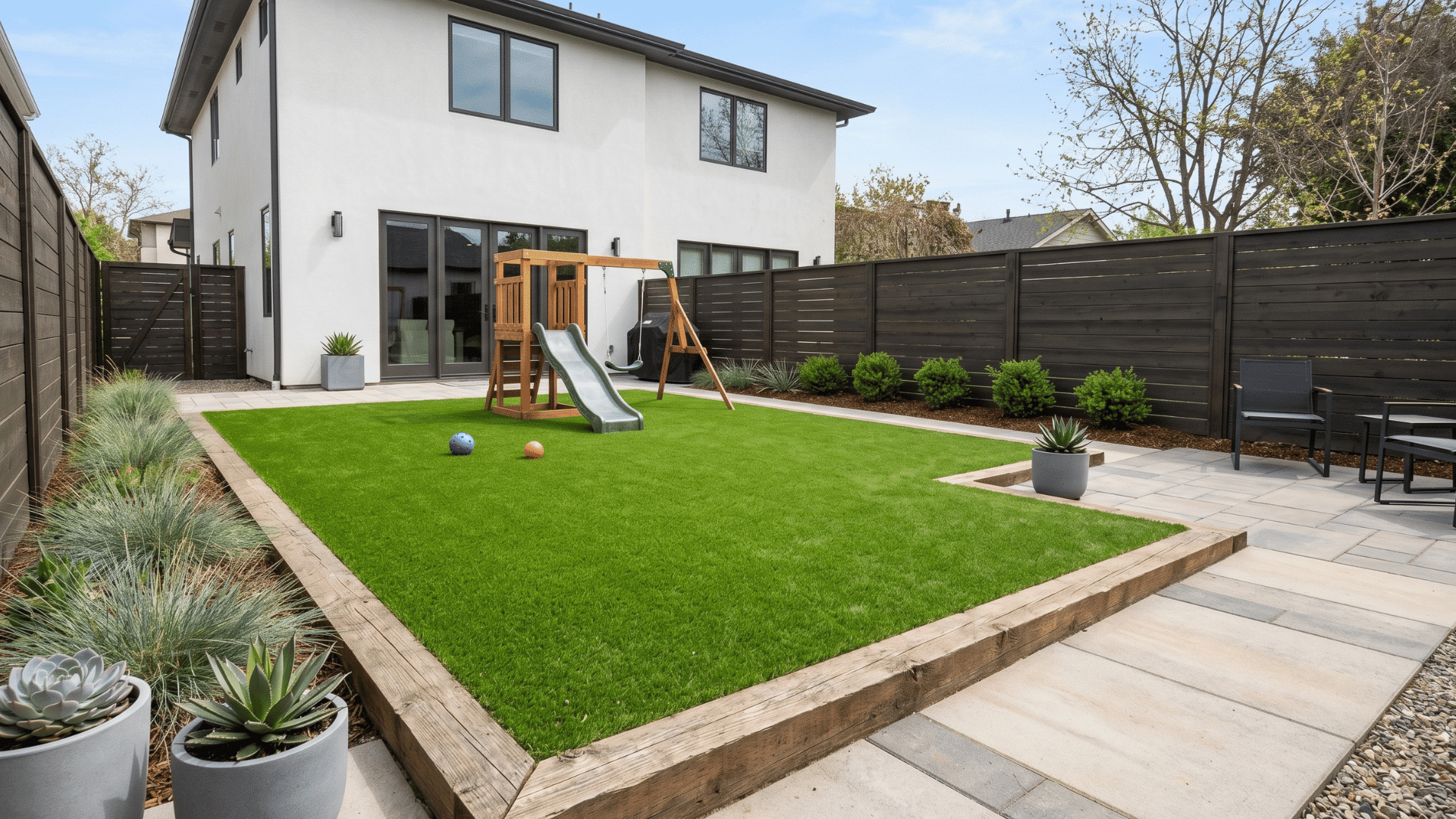 artificial turf play zone backyard with clean paving and open outdoor layout in daylight