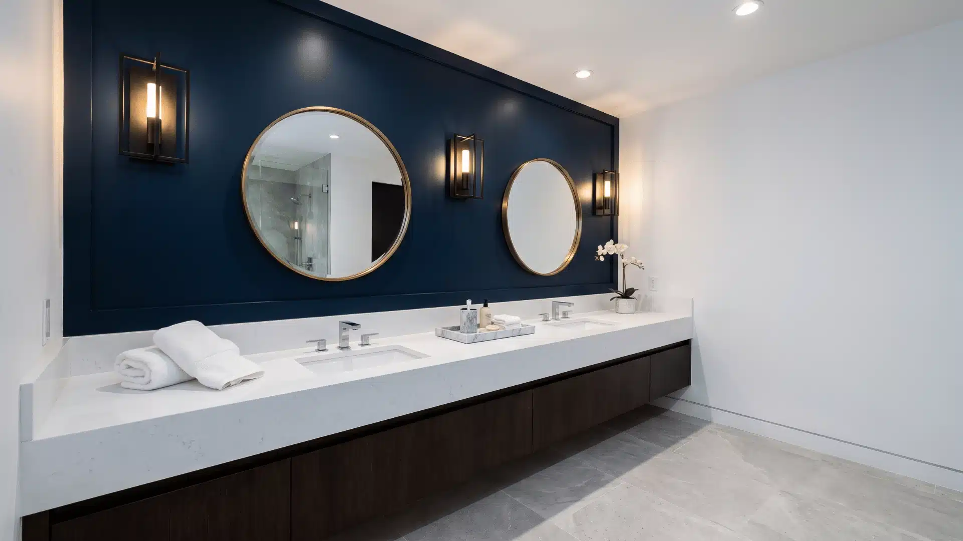 Bathroom with deep navy accent wall behind vanity mirror