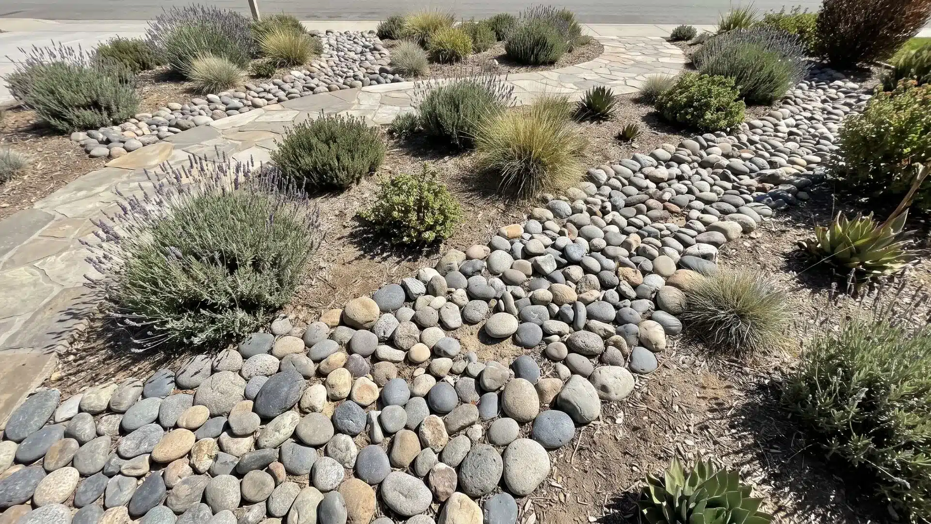 River rock filling empty yard spaces to create a clean, low-maintenance landscape surface.