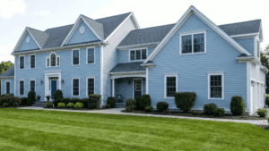 Large freshly painted house with a green lawn in front and clean exterior surfaces.