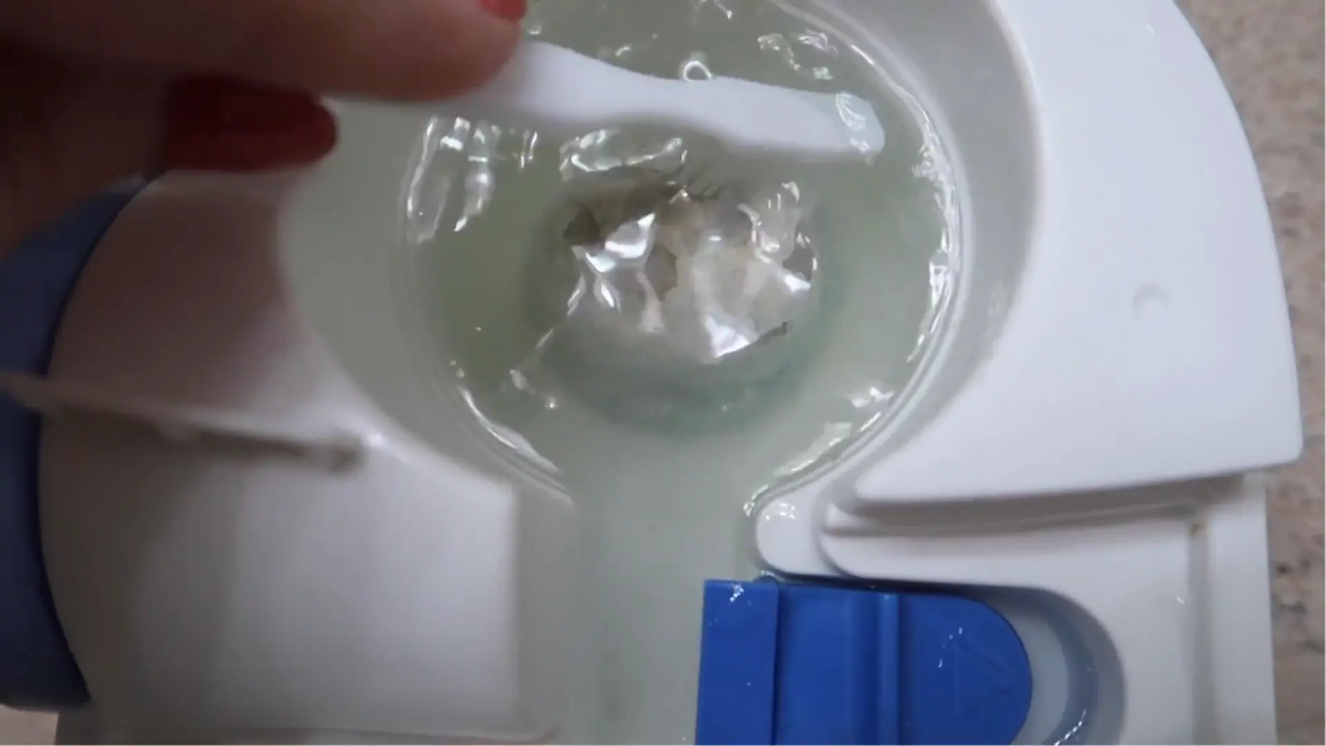 Soft toothbrush gently scrubbing loosened mineral buildup from the heating element inside a warm-mist humidifier.