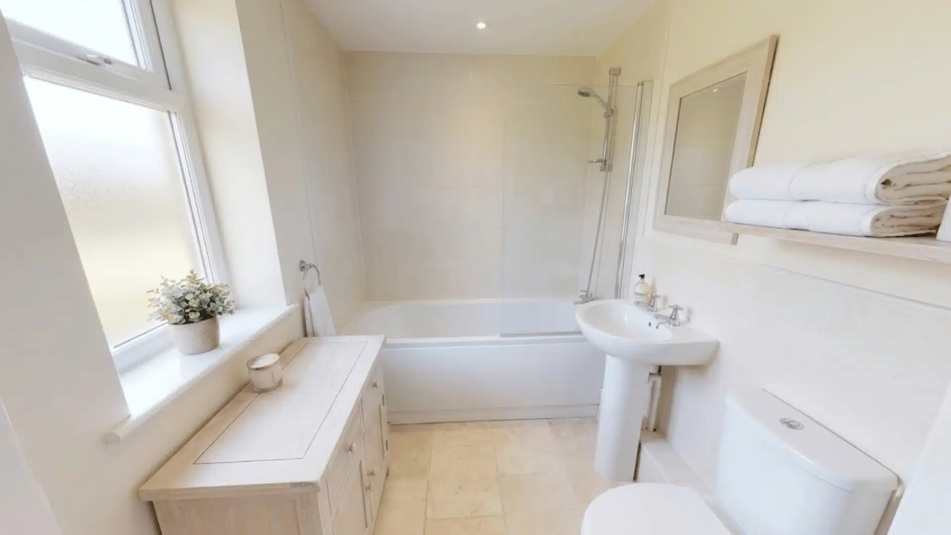 Light-colored finishes throughout small bathroom