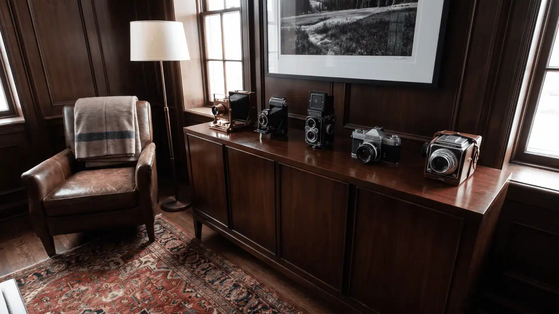 Vintage camera collection neatly displayed on a wooden cabinet in a men’s room