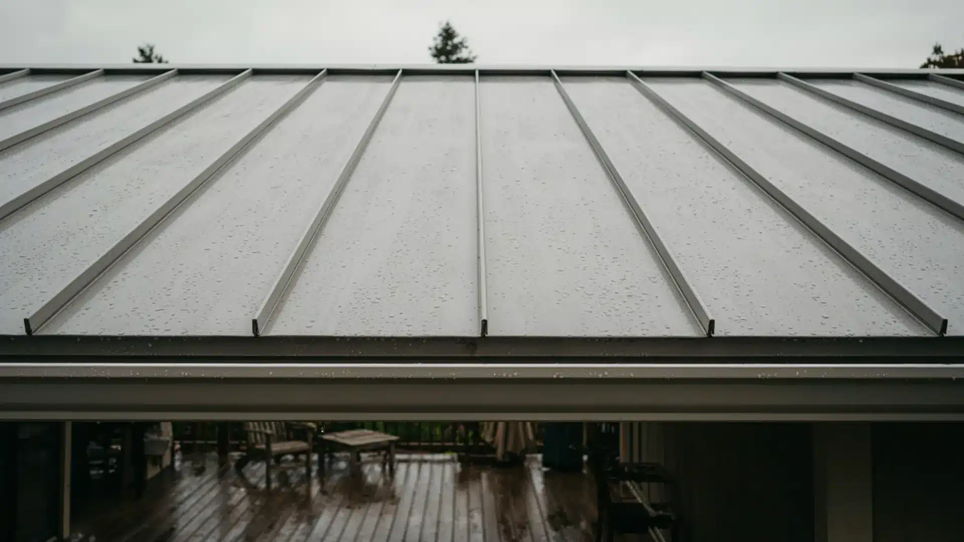 Close-up view of a standing seam metal patio roof wet with rain.