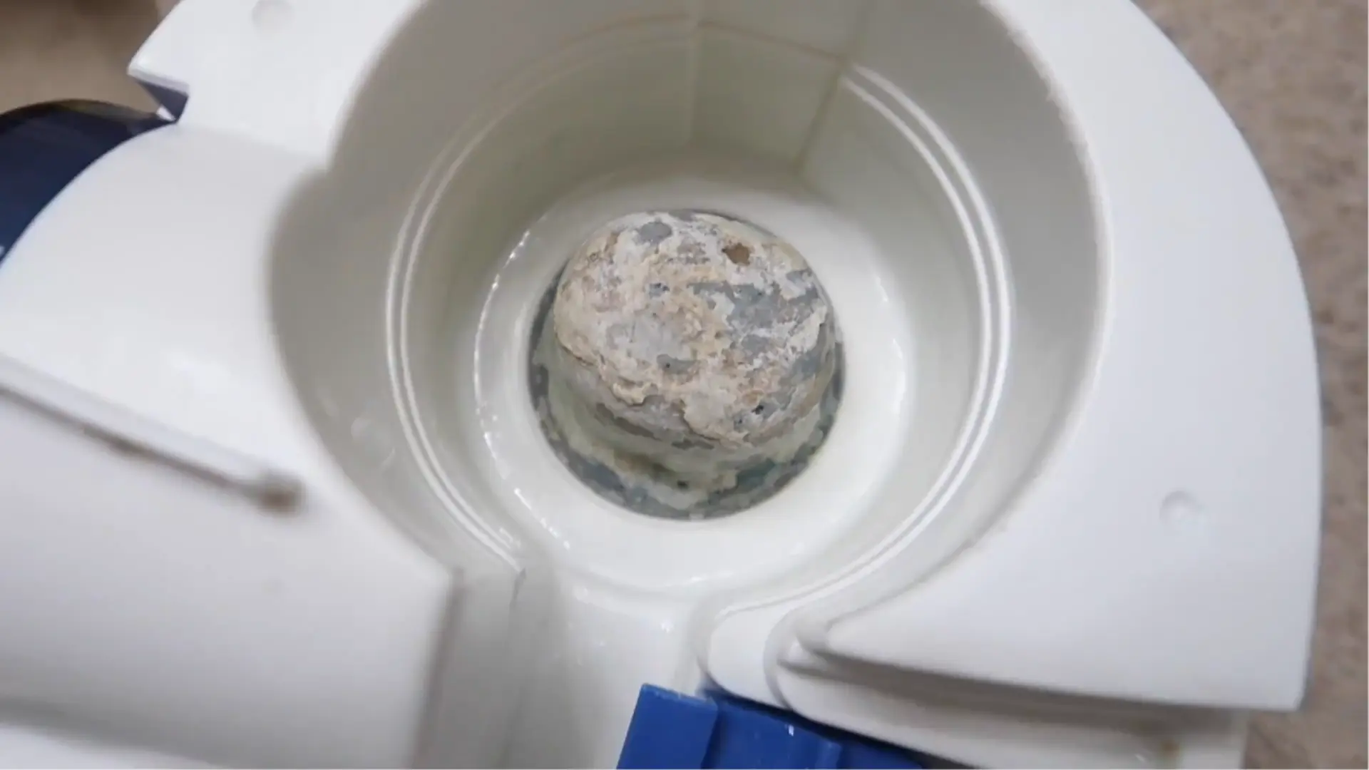 Rinsed warm-mist humidifier base showing remaining mineral scale on the heating element before drying.