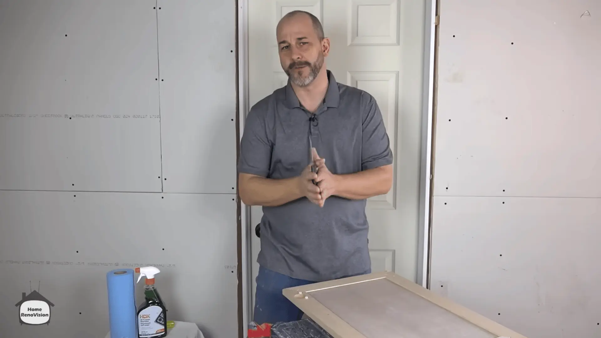 Separate garage work area prepared for cleaning, sanding, priming, and painting a kitchen cabinet door.