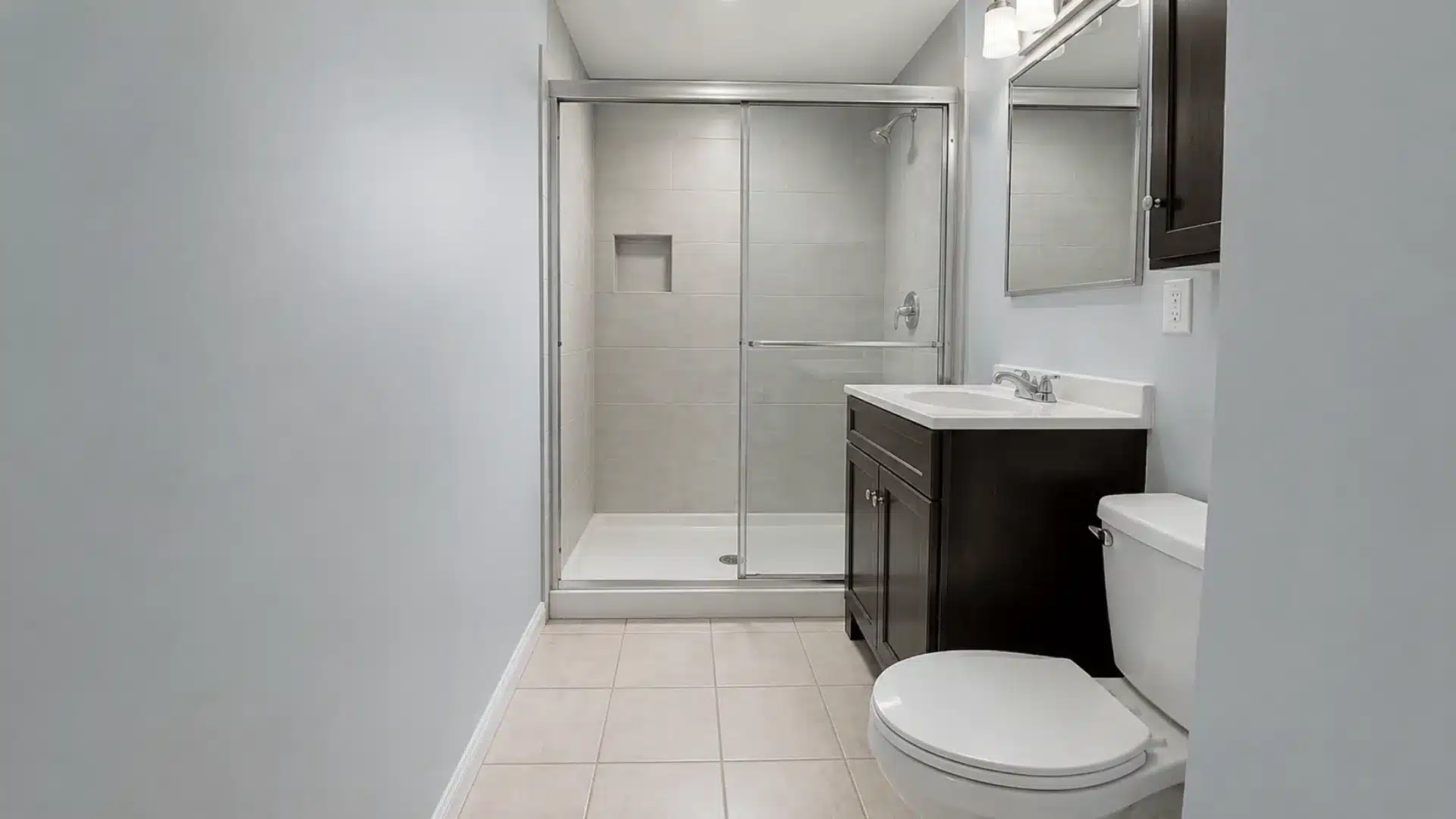 Sliding glass shower doors in a small bathroom with a vanity and toilet
