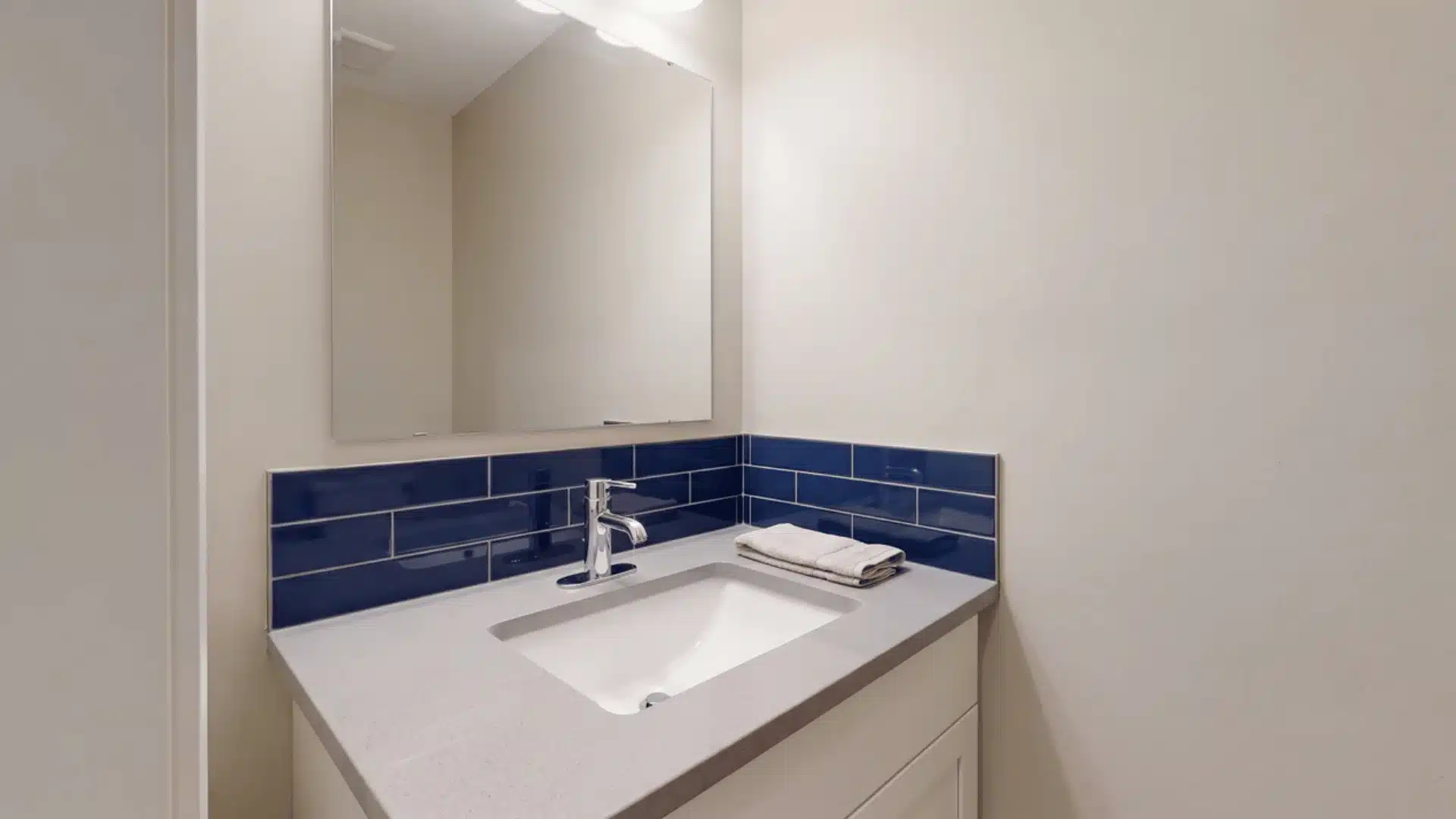 Bathroom vanity with a backsplash behind the sink and contrasting countertop